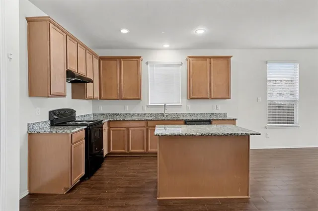 a kitchen with stainless steel appliances granite countertop a stove a sink and a microwave