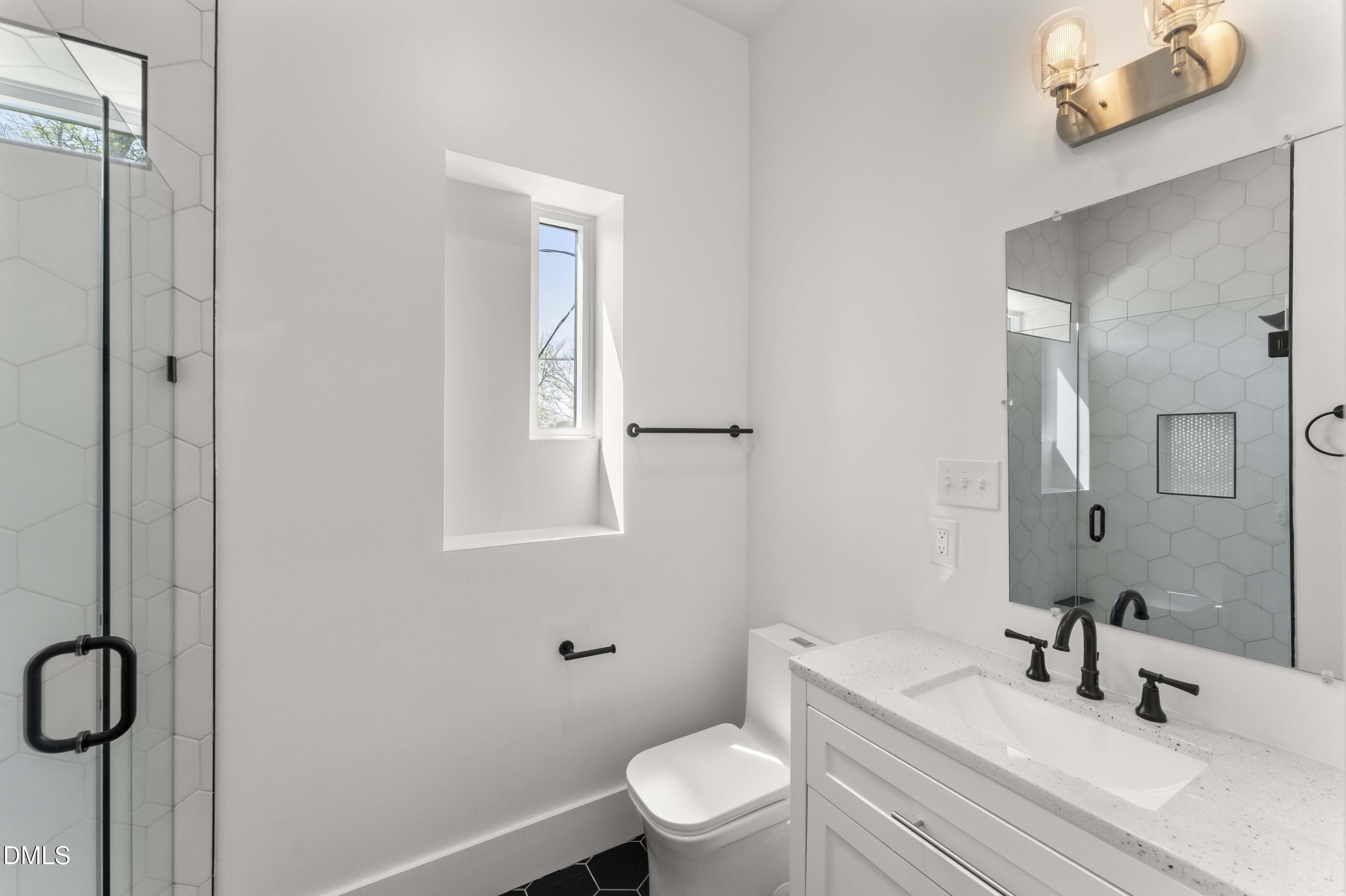 203 Nelson Street Durham, NC 27707 - Photo 18 of 29 a bathroom with a sink a toilet and a mirror