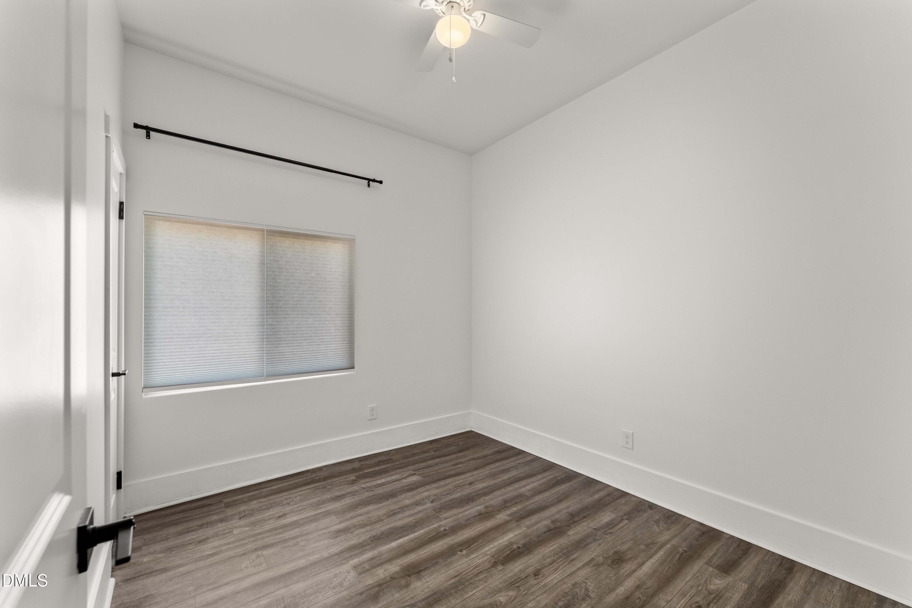 203 Nelson Street Durham, NC 27707 - Photo 22 of 29 an empty room with wooden floor and a chandelier fan