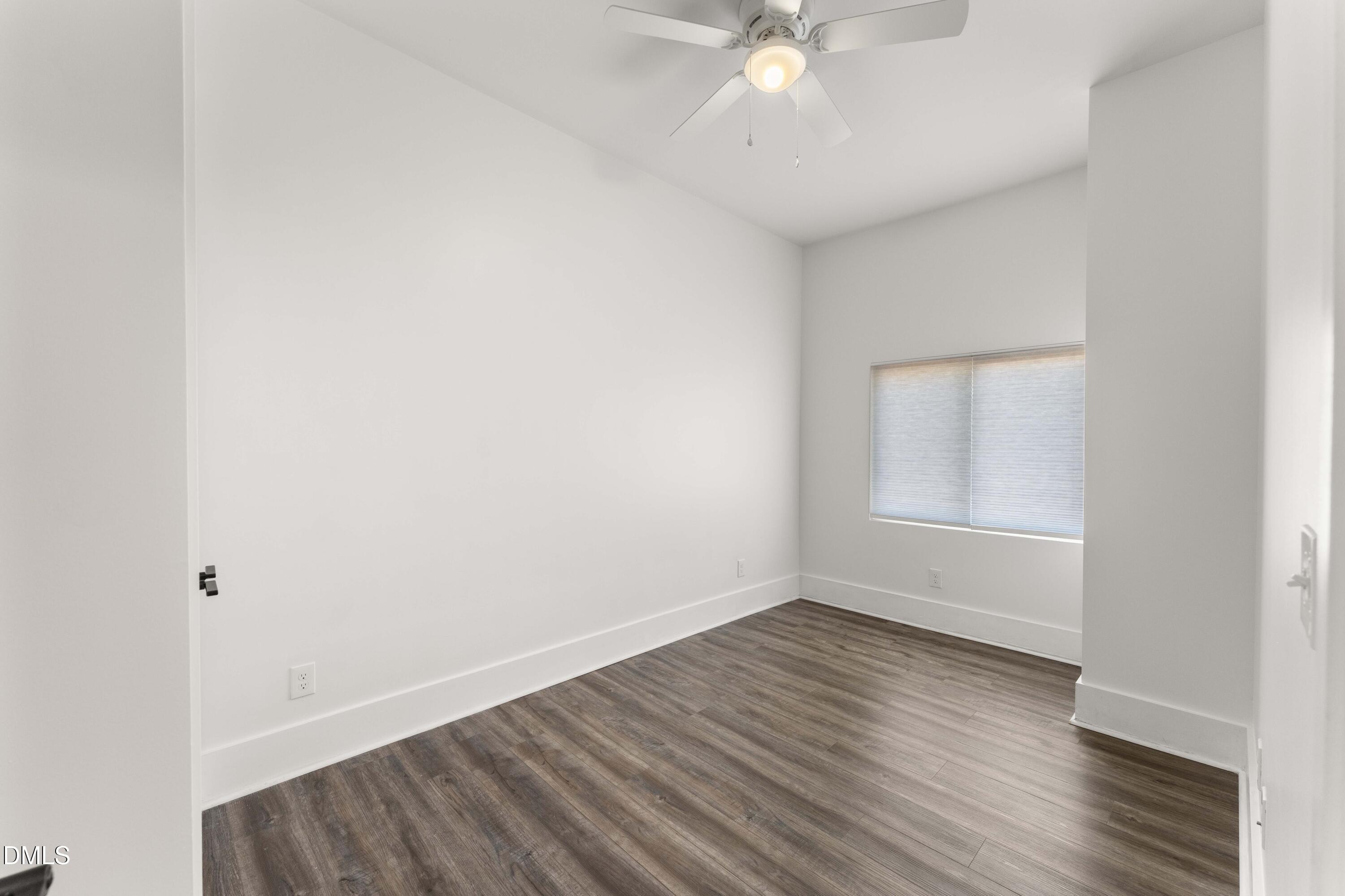 203 Nelson Street Durham, NC 27707 - Photo 23 of 29 an empty room with wooden floor and fan