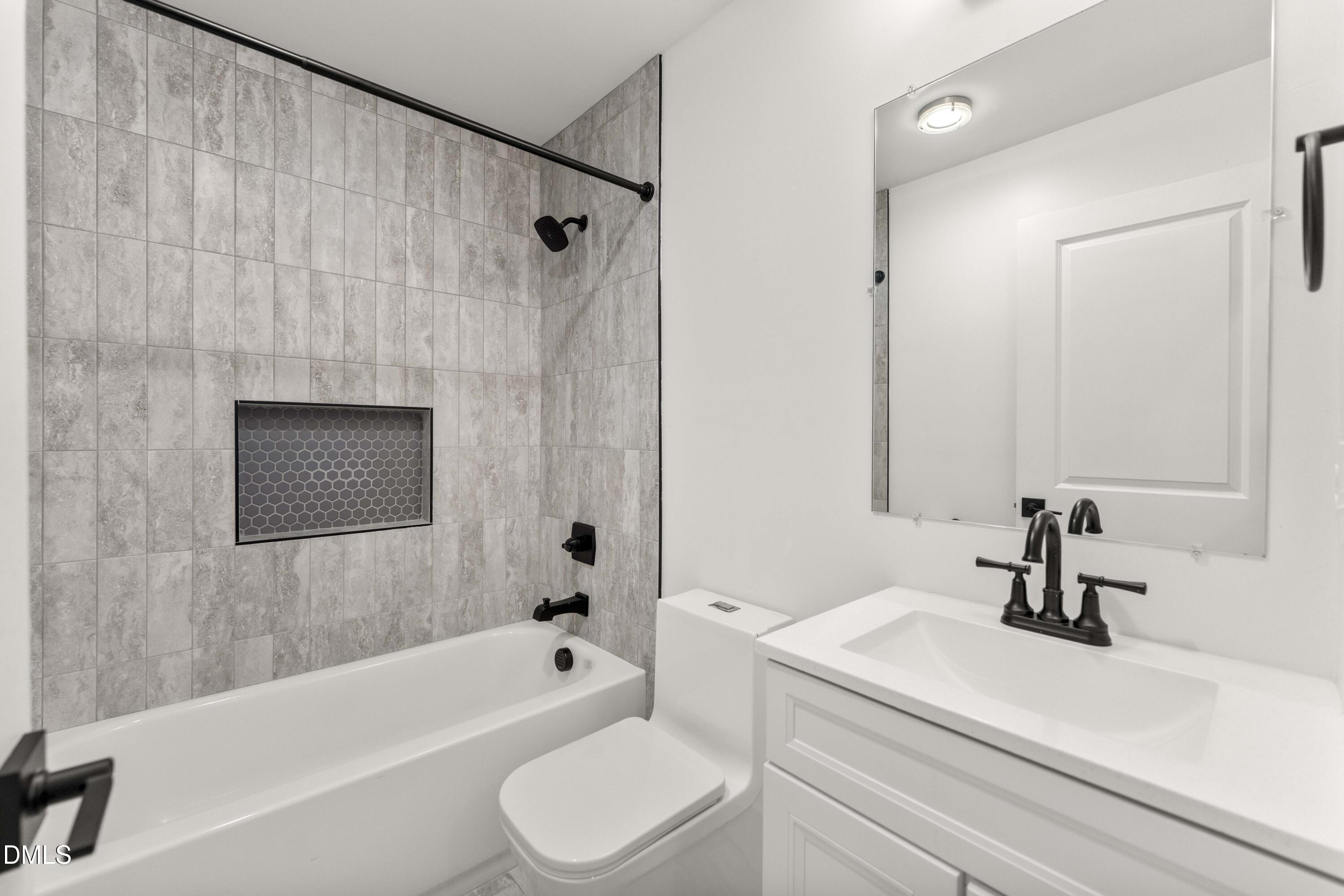 203 Nelson Street Durham, NC 27707 - Photo 24 of 29 a bathroom with a sink a toilet a shower curtain and a bath tub