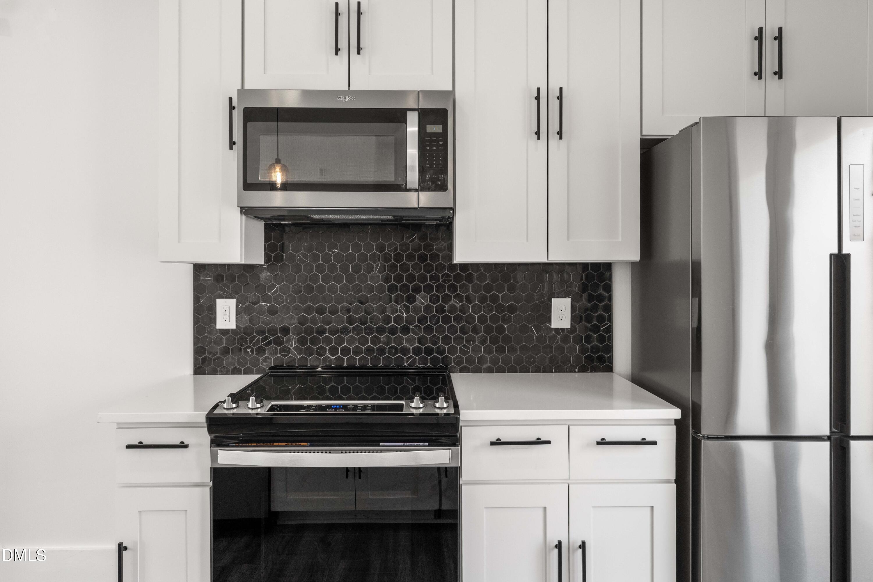 203 Nelson Street Durham, NC 27707 - Photo 4 of 29 a kitchen with stainless steel appliances a stove a microwave and a refrigerator