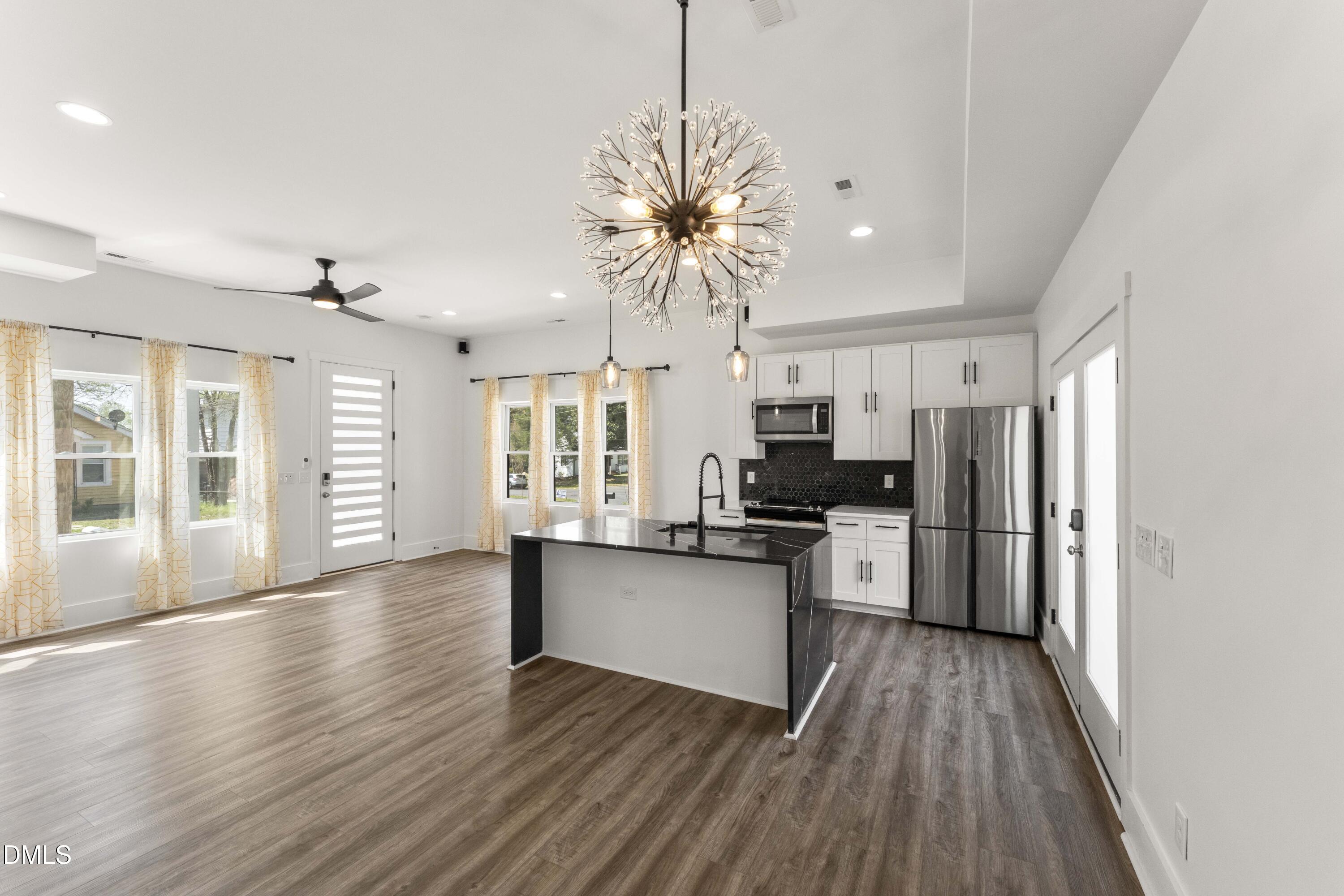 203 Nelson Street Durham, NC 27707 - Photo 5 of 29 a kitchen with stainless steel appliances a refrigerator a sink dishwasher a stove and white countertops with wooden floor