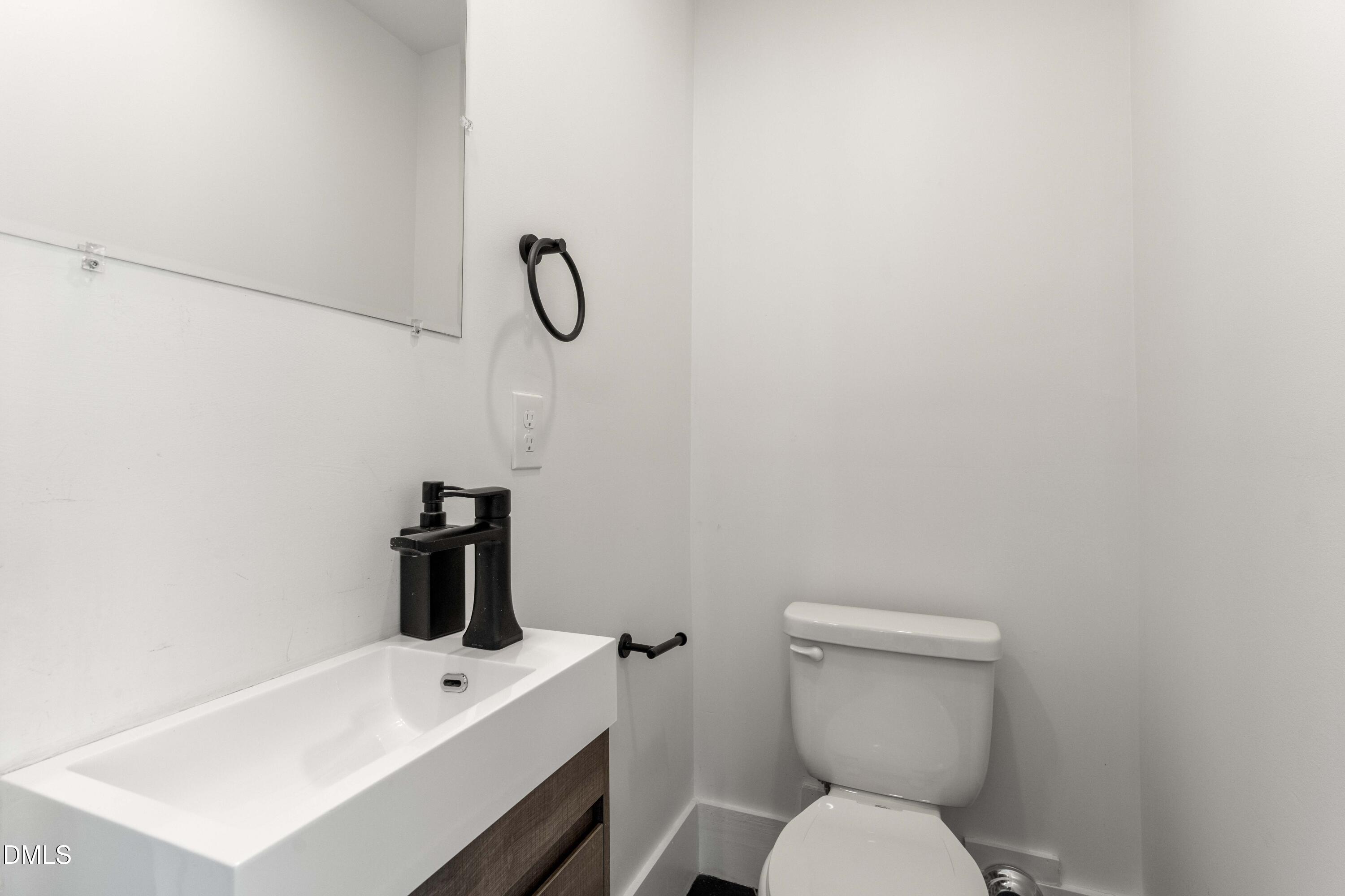 203 Nelson Street Durham, NC 27707 - Photo 9 of 29 a bathroom with a toilet sink and mirror