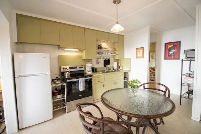 a kitchen with refrigerator and chairs