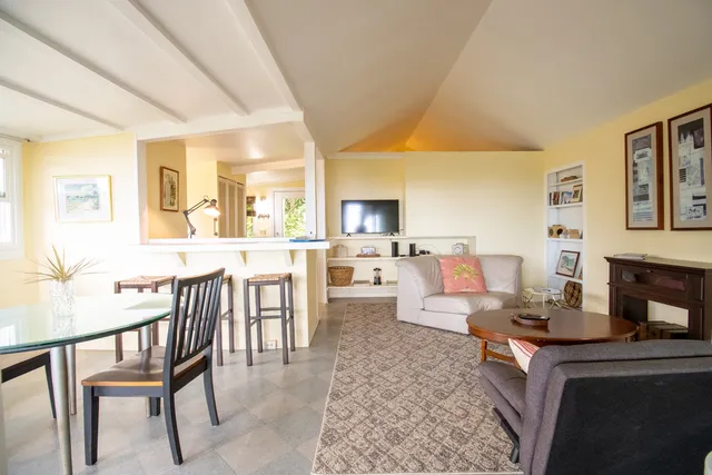 a living room with furniture a fireplace and a large window