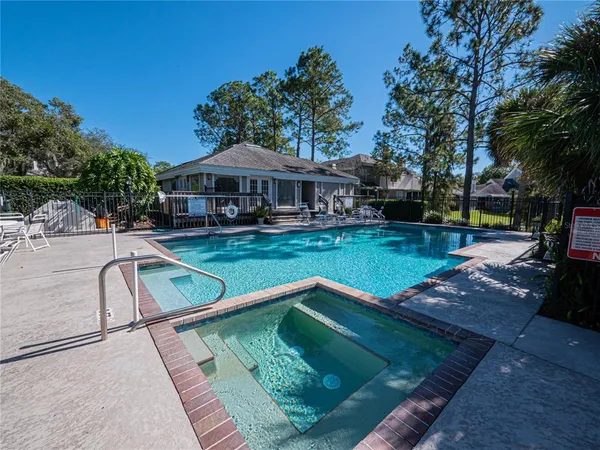 a view of a swimming pool with a patio and a yard