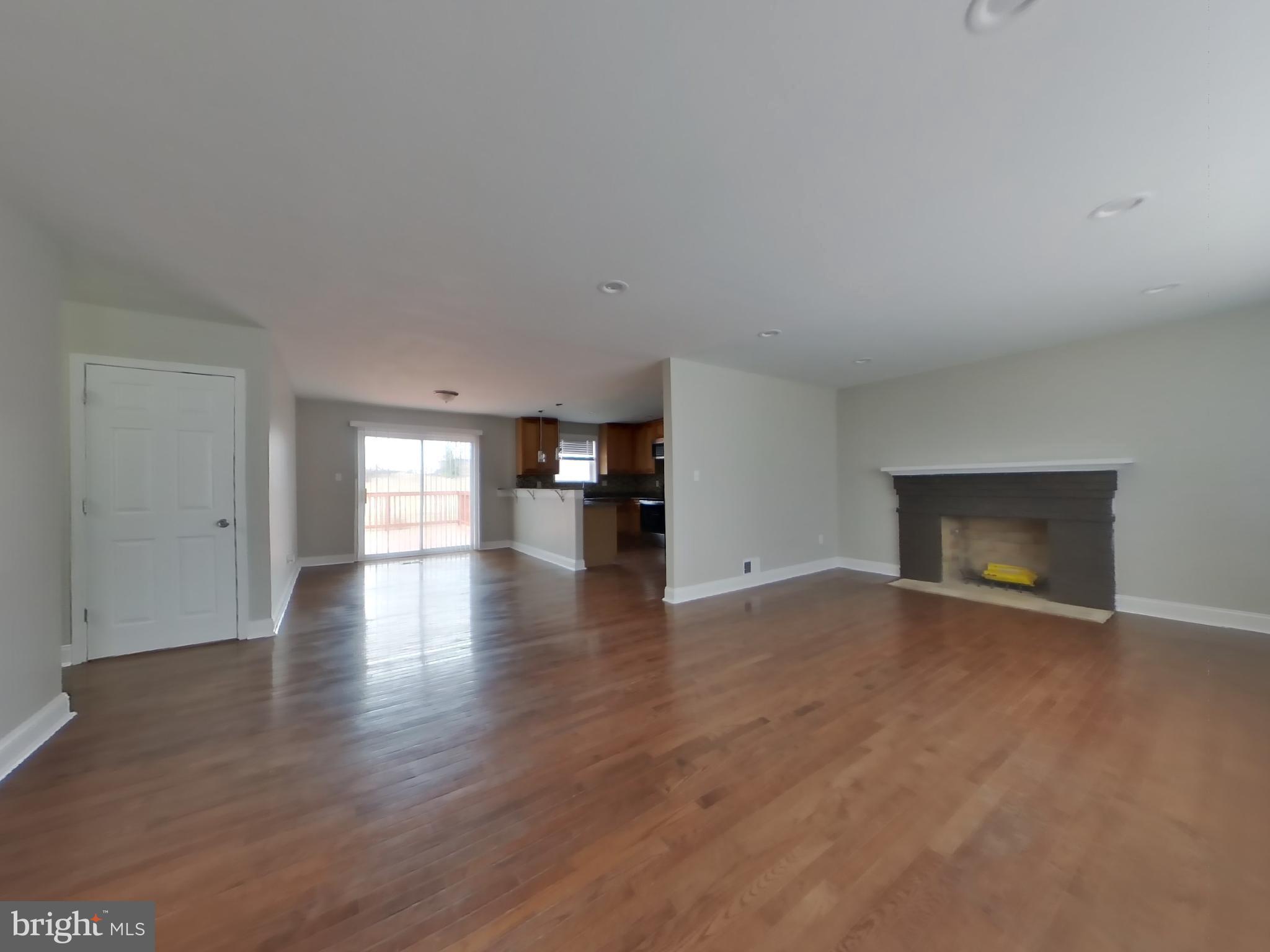 2000 Gaither Street Temple Hills, MD 20748 - Photo 2 of 21 a view of empty room with wooden floor and fireplace