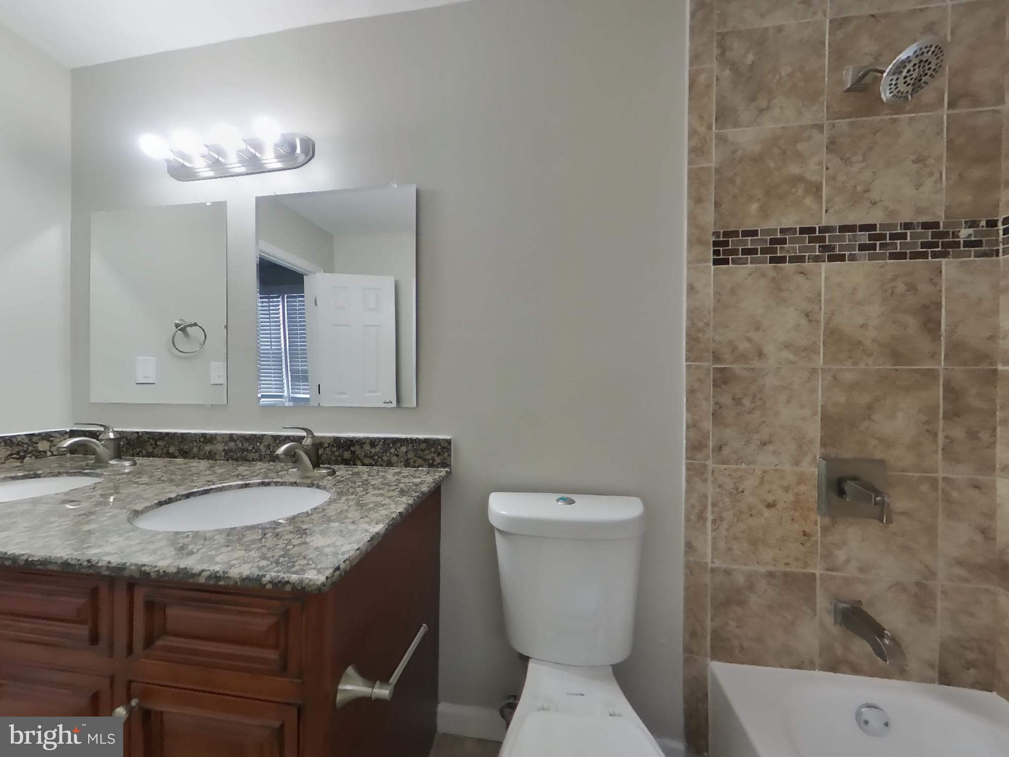 2000 Gaither Street Temple Hills, MD 20748 - Photo 9 of 21 a bathroom with a granite countertop sink toilet and shower