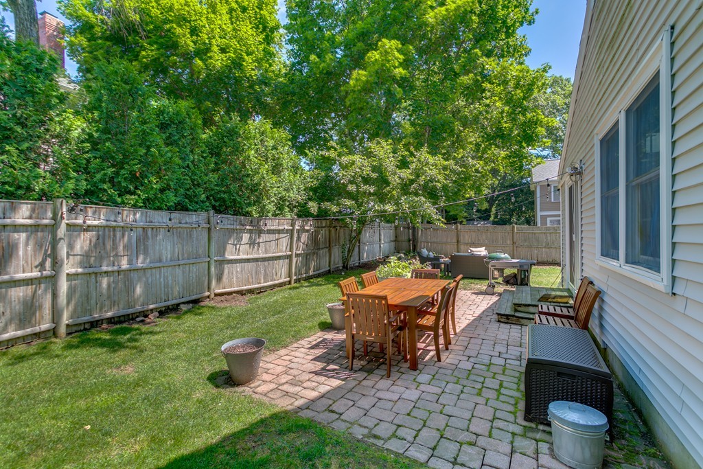 68 Chesterton Road Wellesley, MA 02481 - Photo 24 of 27 a view of a backyard with table and chairs and a couple of wooden fence