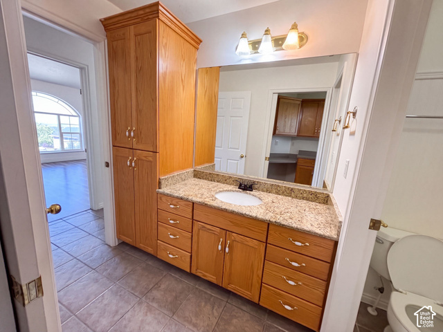 232 Bugle Way Providence, UT 84332 - Photo 12 of 36 Vanity with an integrated sink, granite-style countertop, wood-finish cabinetry, and tiled flooring