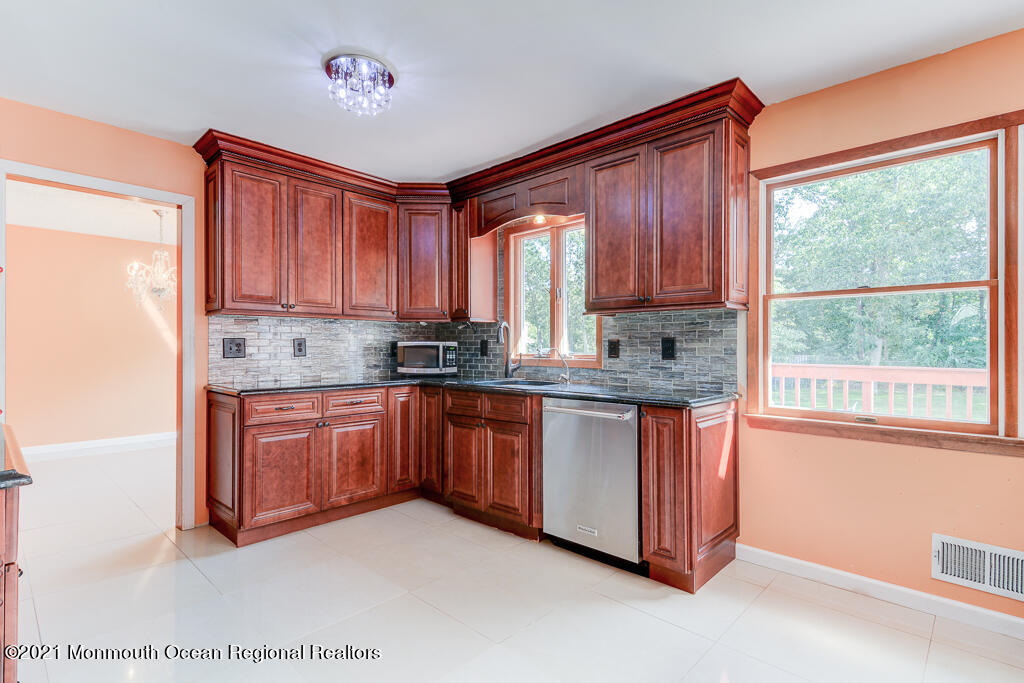 313 Emberly Road Brick, NJ 08723 - Photo 11 of 32 a kitchen with stainless steel appliances granite countertop wooden cabinets a stove a sink and dishwasher with a large window