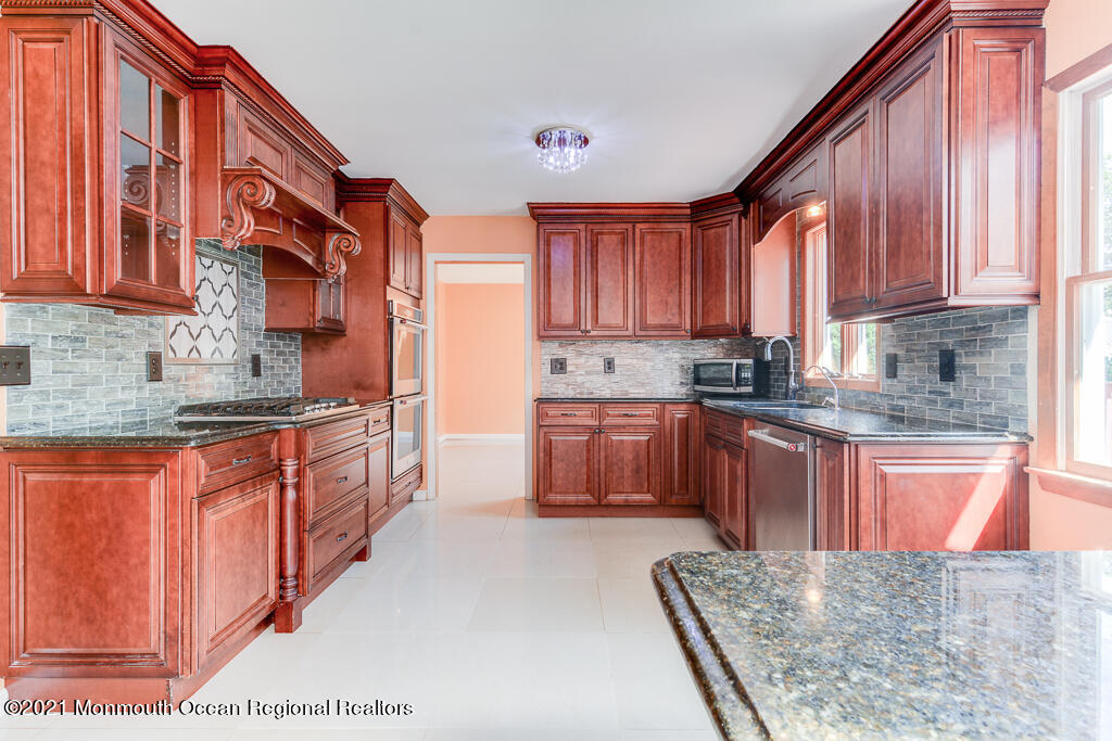 313 Emberly Road Brick, NJ 08723 - Photo 12 of 32 a kitchen with stainless steel appliances granite countertop a stove a sink dishwasher and a refrigerator