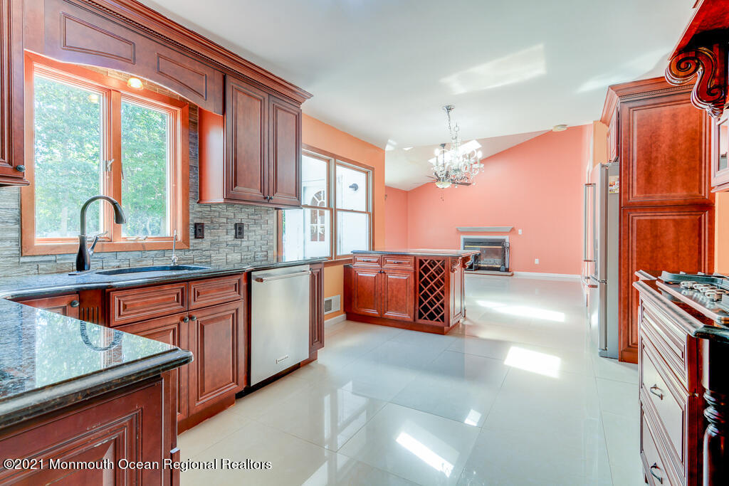 313 Emberly Road Brick, NJ 08723 - Photo 8 of 32 a kitchen with stainless steel appliances granite countertop a stove a sink and dishwasher cabinets with wooden floor