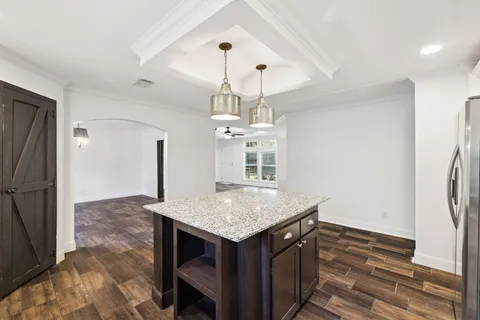 a kitchen with granite countertop white cabinets and white appliances