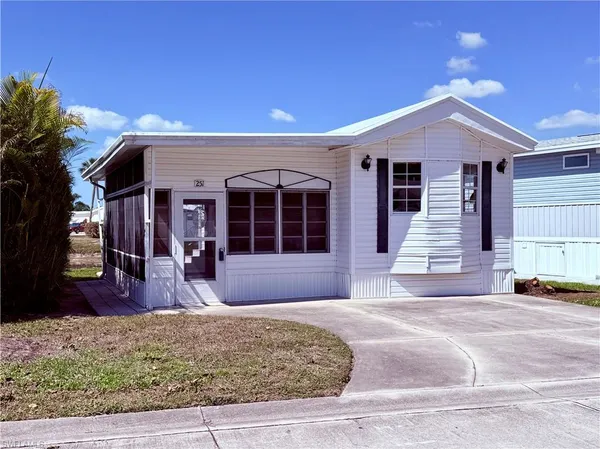 a front view of a house with garden and seating space