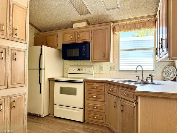 a kitchen with stainless steel appliances a stove a microwave and a sink