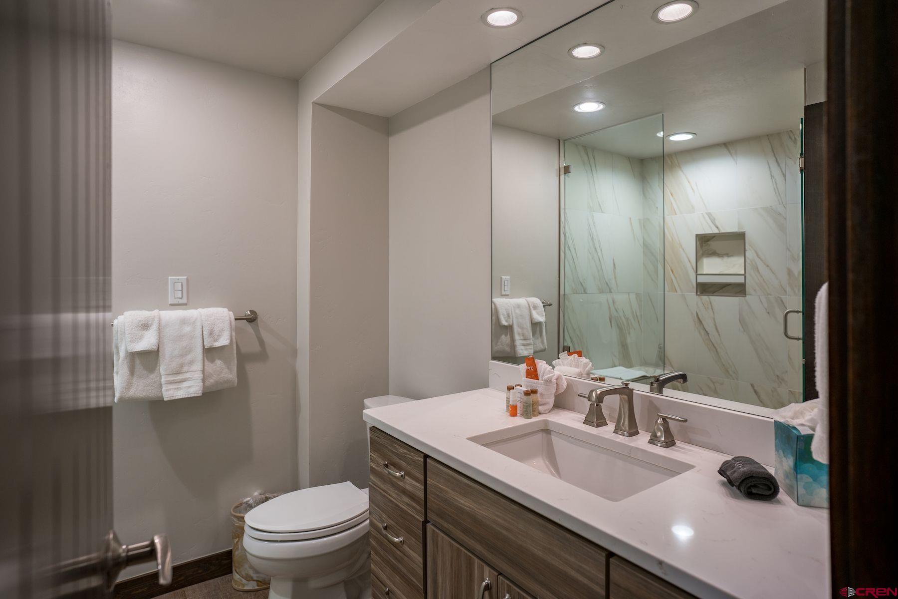 314 Tamarron Drive, Unit 342 Durango, CO 81301 - Photo 13 of 17 a bathroom with a granite countertop sink a toilet and a mirror