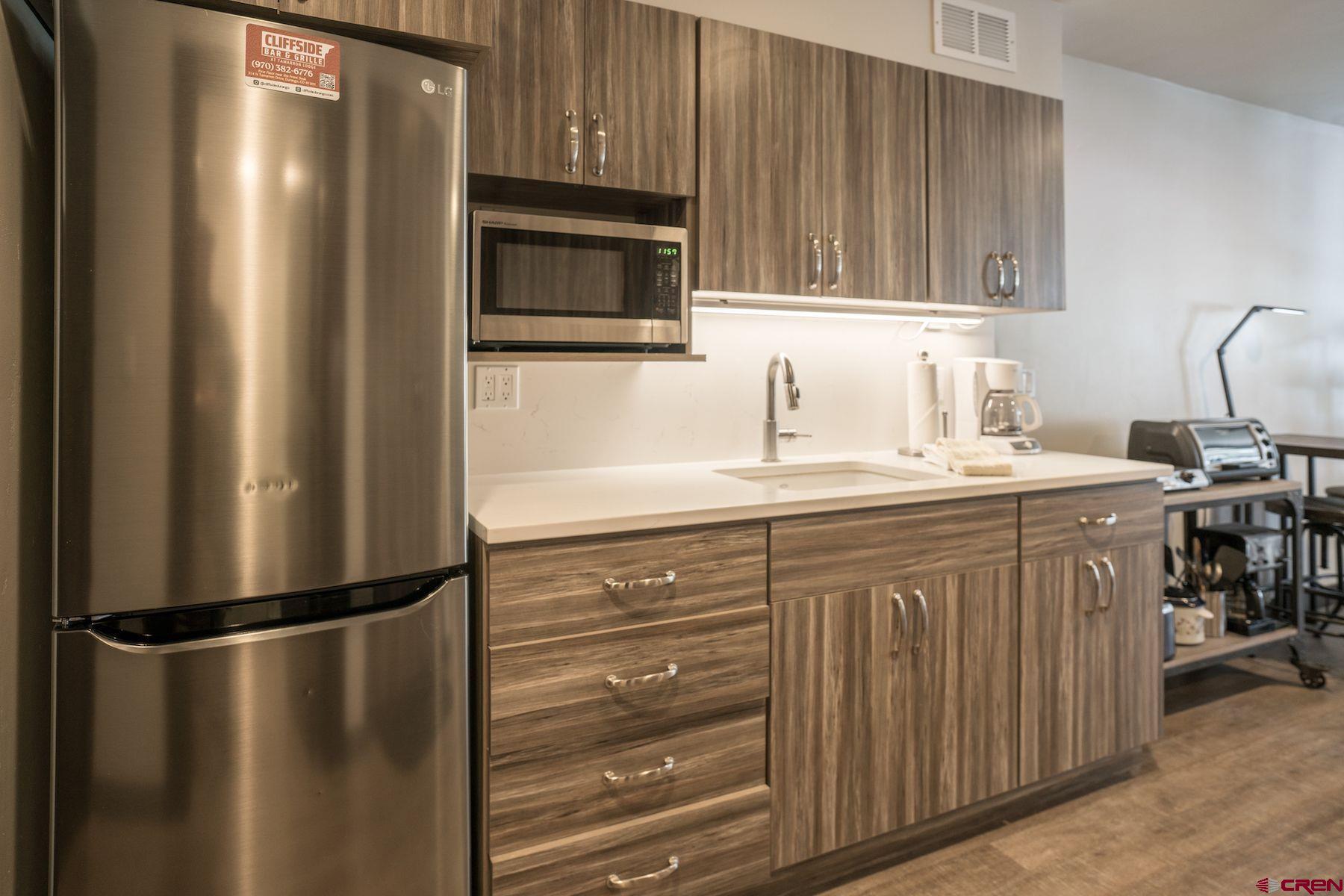 314 Tamarron Drive, Unit 342 Durango, CO 81301 - Photo 4 of 17 a kitchen with a refrigerator sink and cabinets