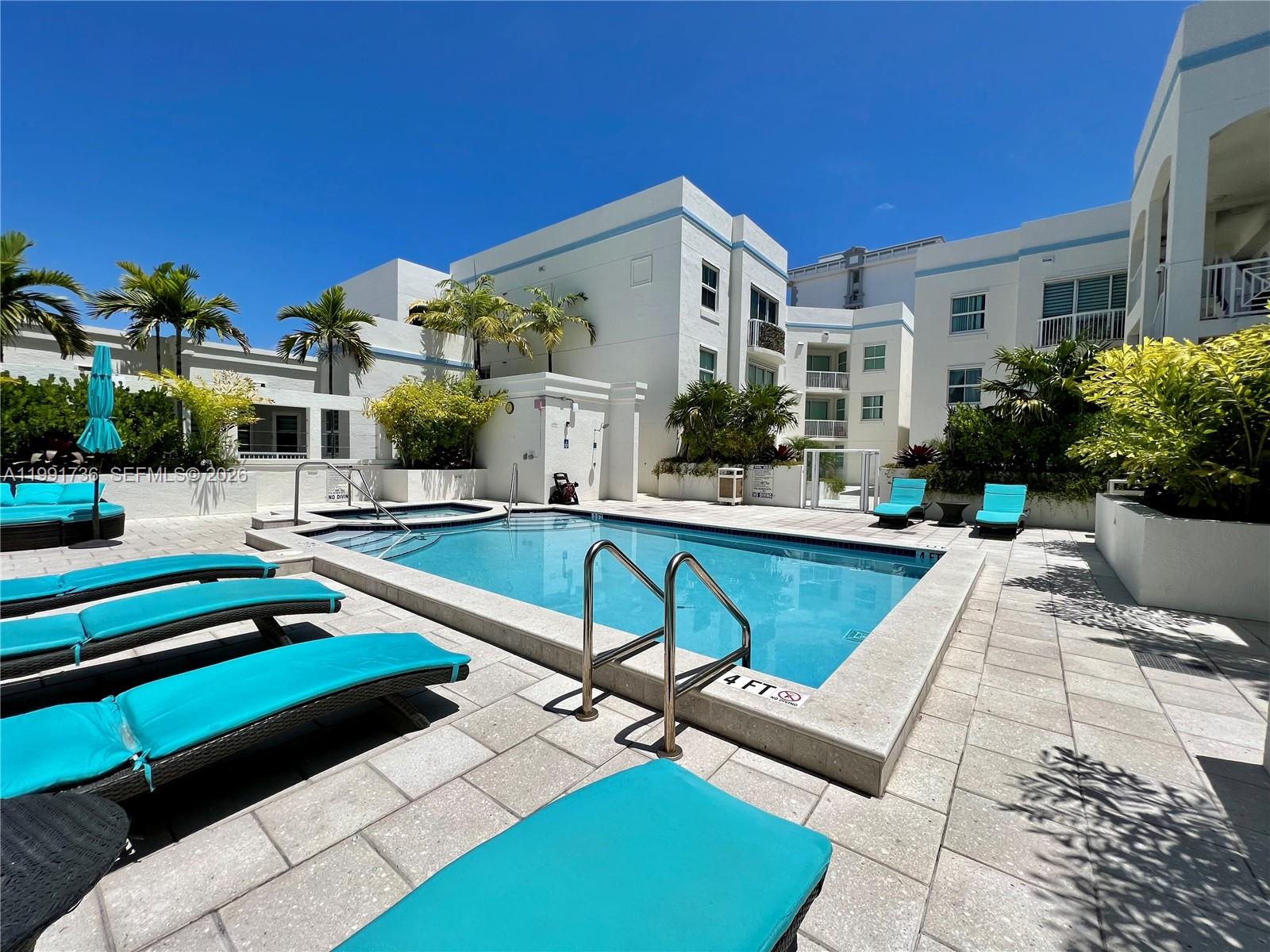 9172 Collins Avenue, Unit 214 Surfside, FL 33154 - Photo 26 of 33 a view of a house with swimming pool and sitting area