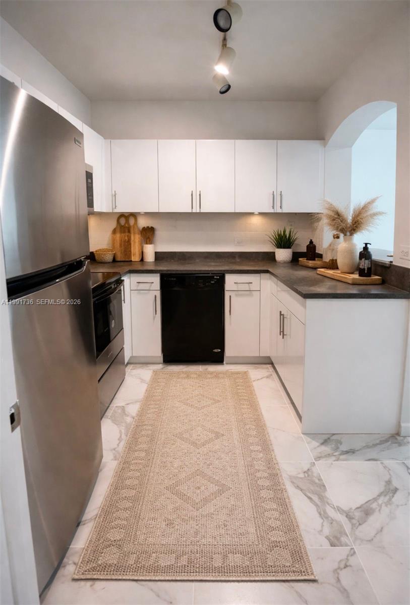 9172 Collins Avenue, Unit 214 Surfside, FL 33154 - Photo 3 of 33 a kitchen with granite countertop a stove top oven a sink dishwasher and a refrigerator with cabinets
