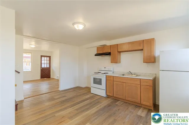 a kitchen with stainless steel appliances granite countertop a sink and cabinets with wooden floor