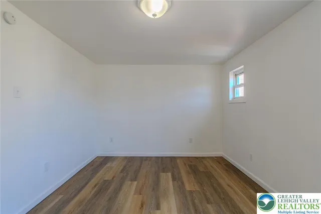 a view of a room with wooden floor and window