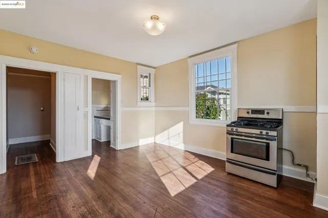 a kitchen with stainless steel appliances cabinets and wooden floor