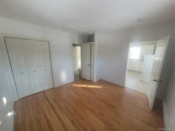 a view of empty room with wooden floor