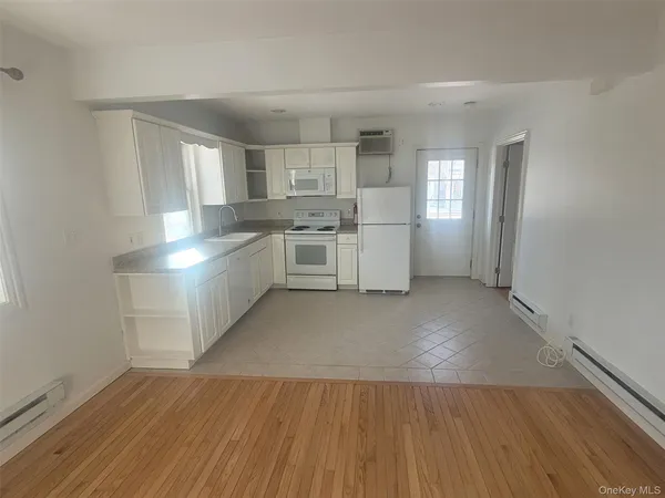 a large kitchen with a wooden floor and a stove top oven