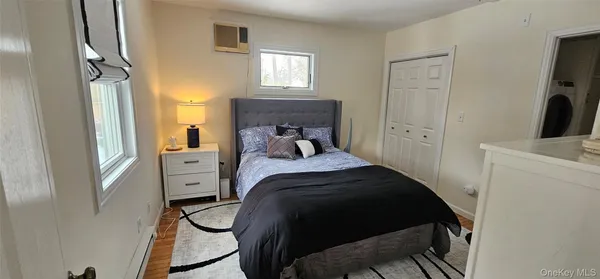 a bedroom with a bed a mirror and a window