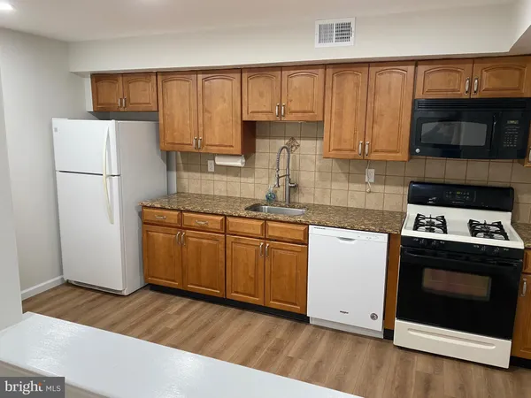 a kitchen with a white stove top oven and refrigerator