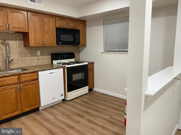 a kitchen with granite countertop white cabinets and white appliances
