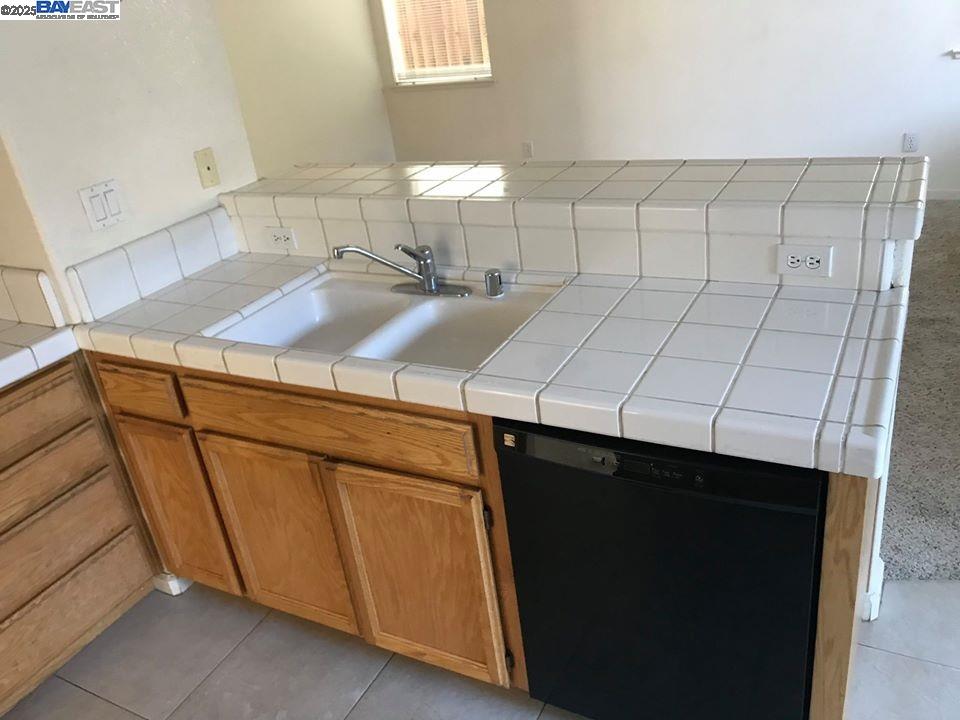 2173 Leafcrest Common Livermore, CA 94551 - Photo 11 of 25 a close view of sink cabinets and washer & dryer