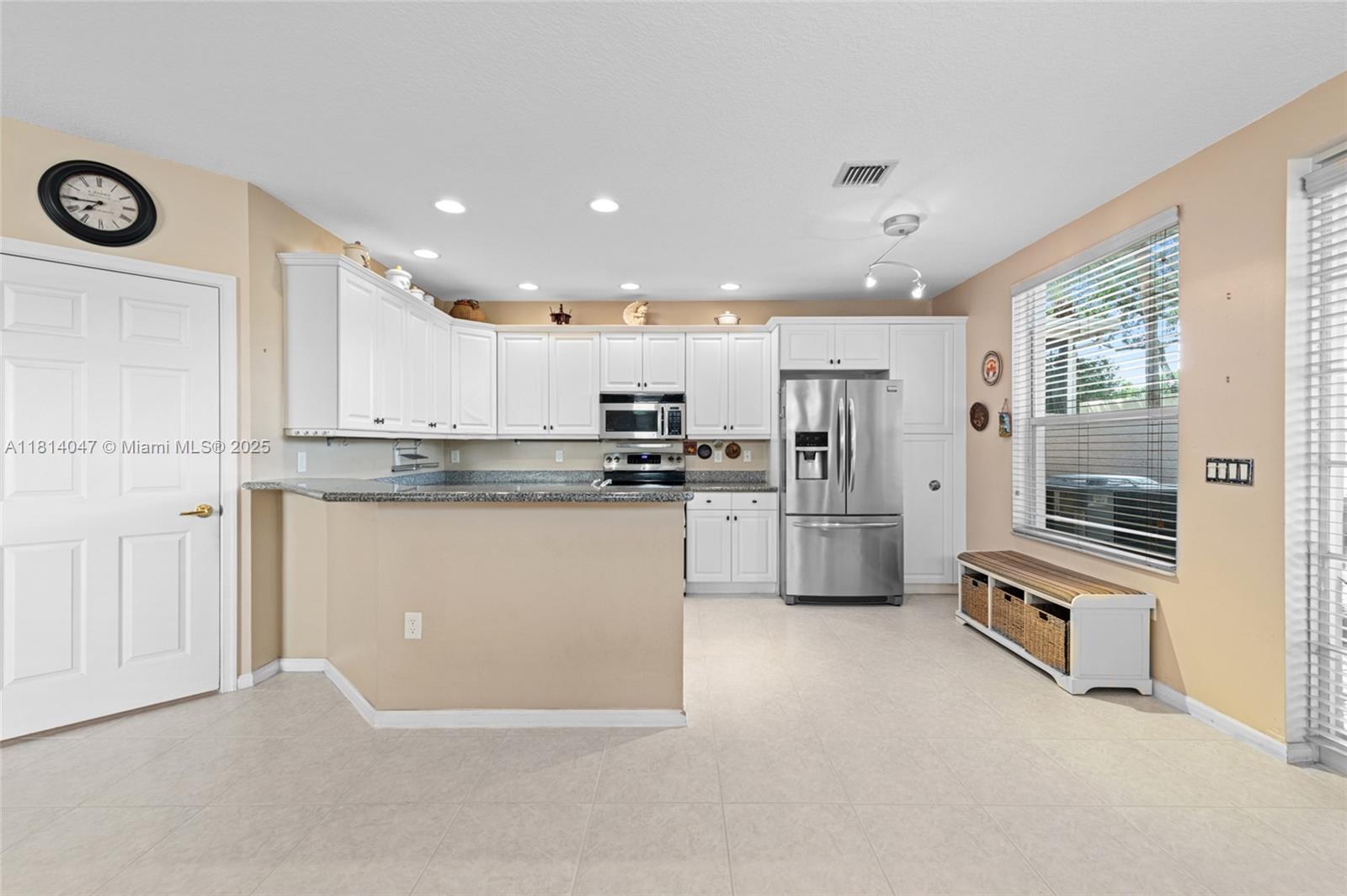 16316 Southwest 48th Street Miramar, FL 33027 - Photo 11 of 37 a kitchen with granite countertop white cabinets and stainless steel appliances