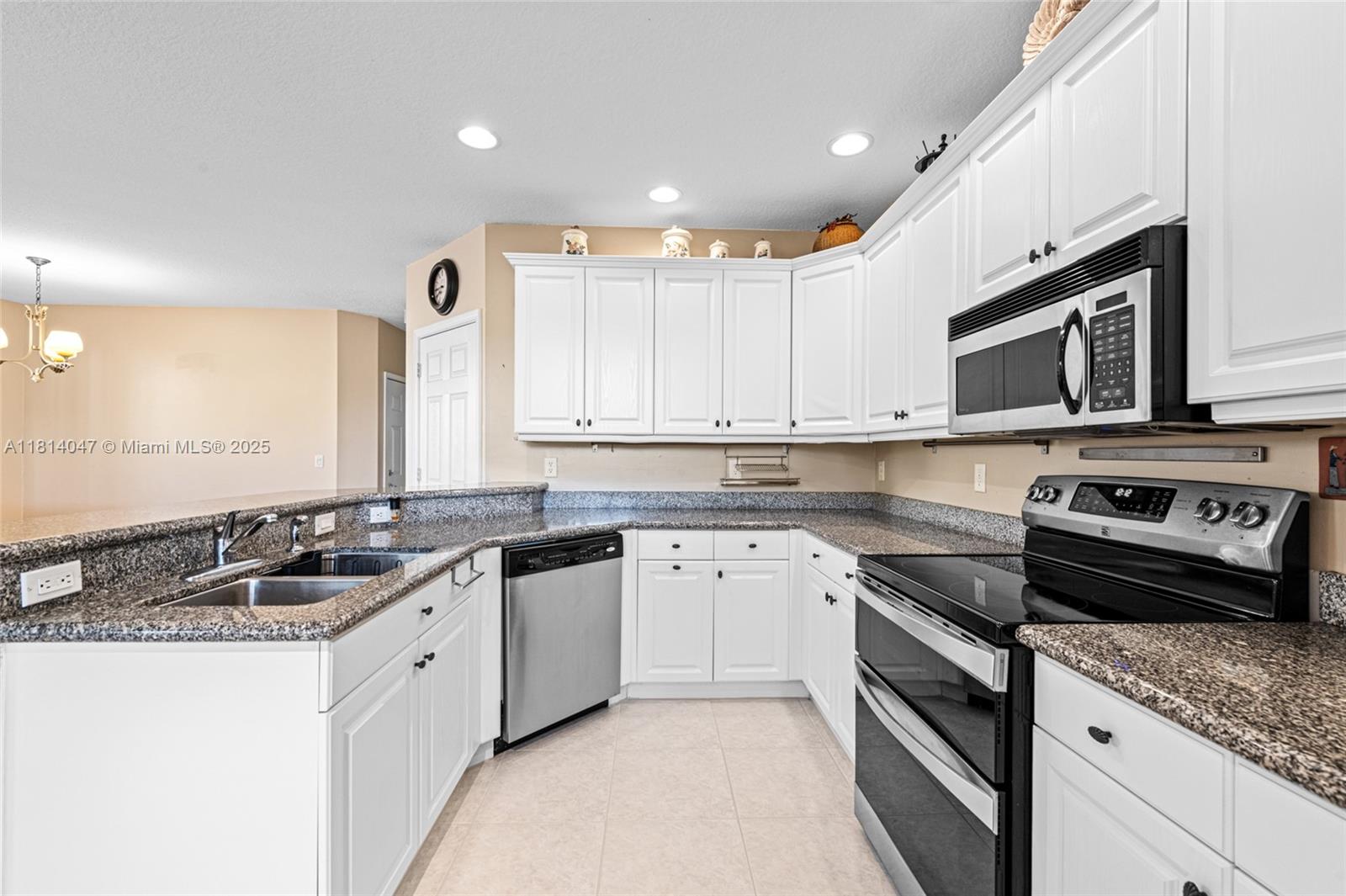 16316 Southwest 48th Street Miramar, FL 33027 - Photo 12 of 37 a kitchen with stainless steel appliances granite countertop a sink stove and microwave