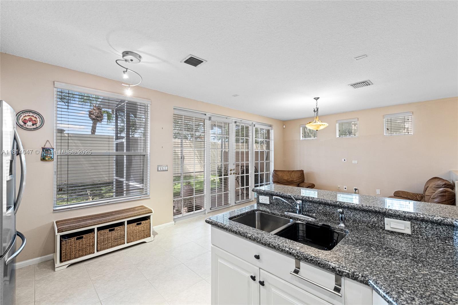 16316 Southwest 48th Street Miramar, FL 33027 - Photo 14 of 37 a kitchen with granite countertop a sink and a refrigerator