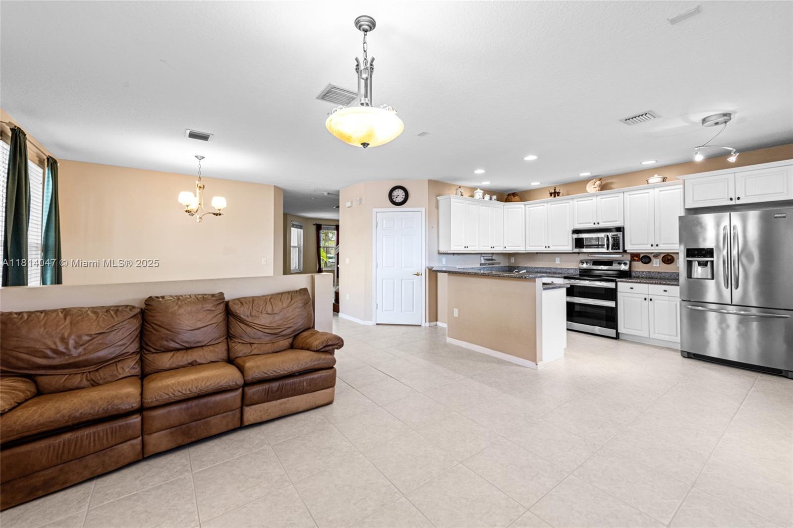 16316 Southwest 48th Street Miramar, FL 33027 - Photo 15 of 37 a view of kitchen with kitchen island stainless steel appliances cabinets a sink and a refrigerator