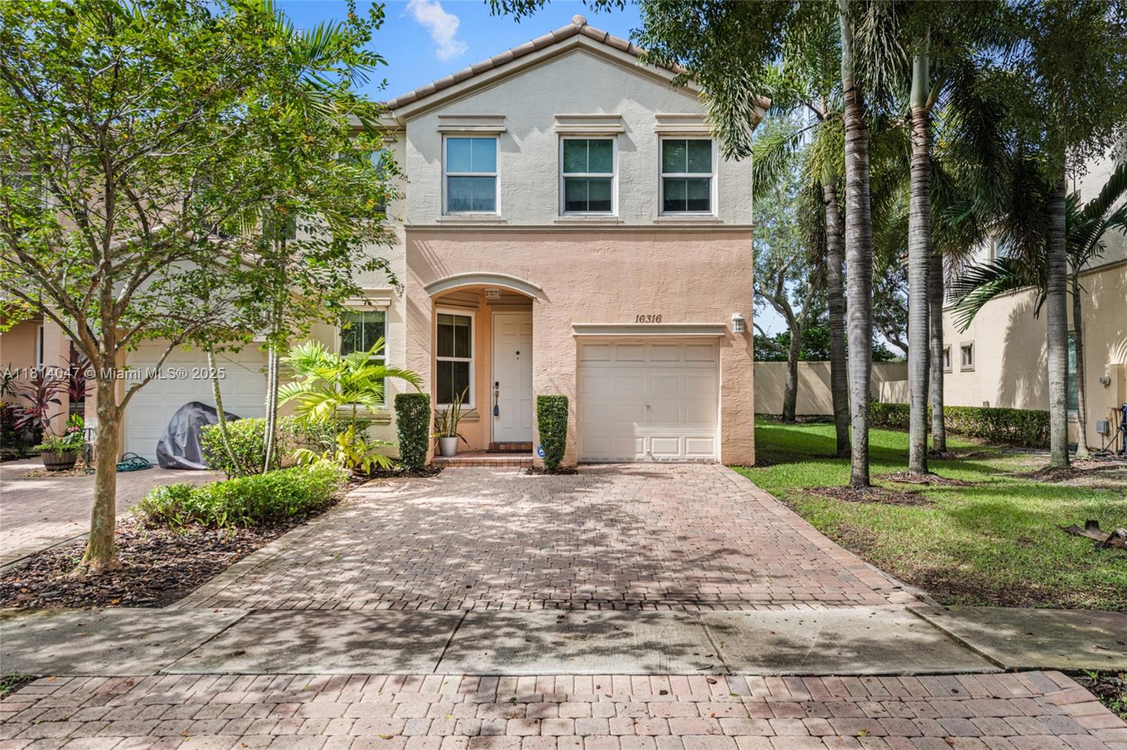 16316 Southwest 48th Street Miramar, FL 33027 - Photo 2 of 37 a front view of a house with a yard and garage