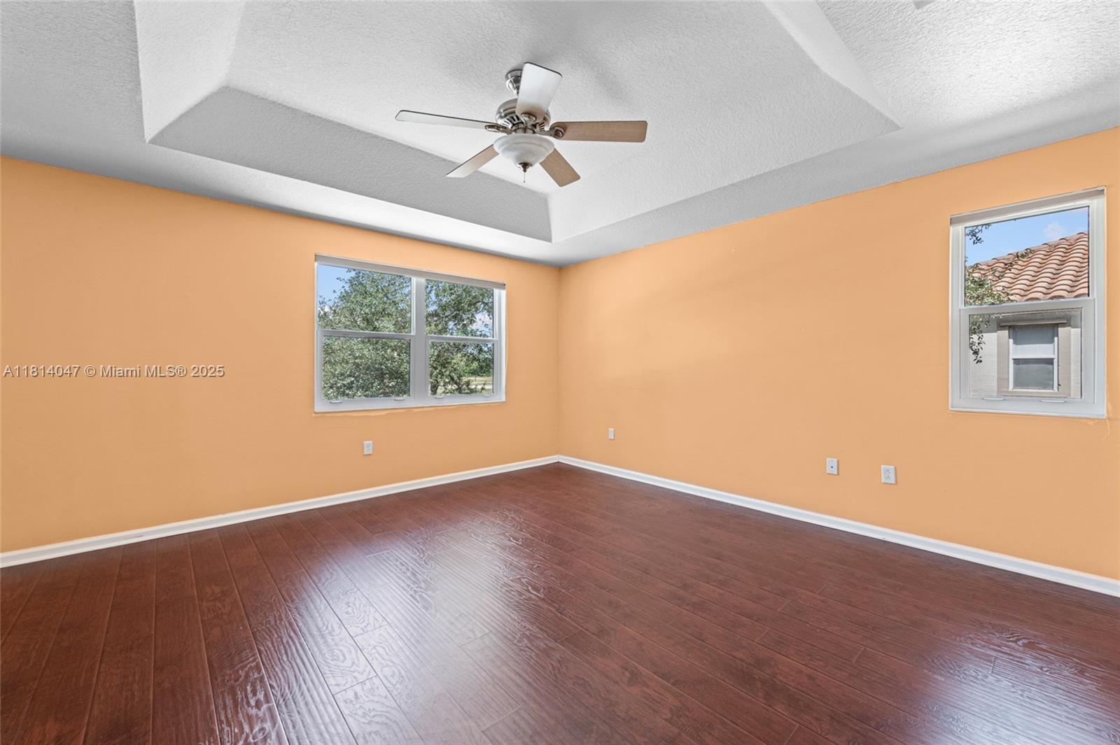 16316 Southwest 48th Street Miramar, FL 33027 - Photo 21 of 37 an empty room with wooden floor chandelier fan and windows