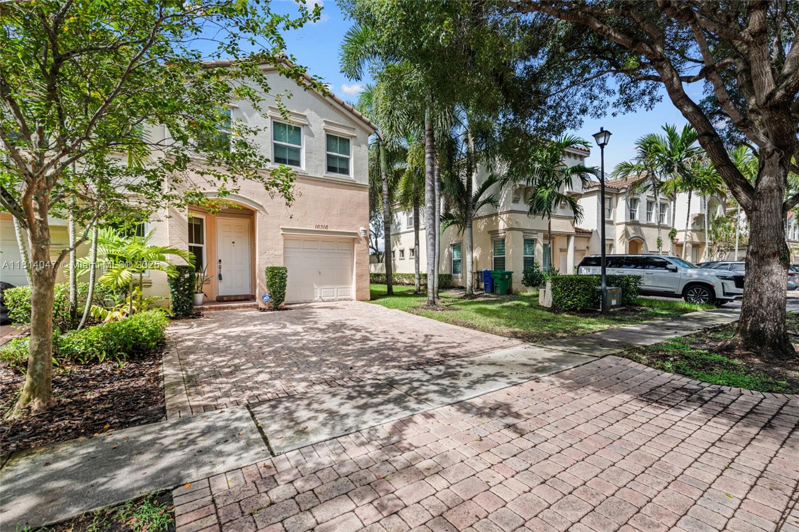 16316 Southwest 48th Street Miramar, FL 33027 - Photo 3 of 37 a front view of a house with a yard and trees