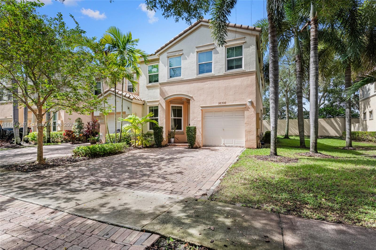 16316 Southwest 48th Street Miramar, FL 33027 - Photo 4 of 37 a front view of a house with a yard and garage