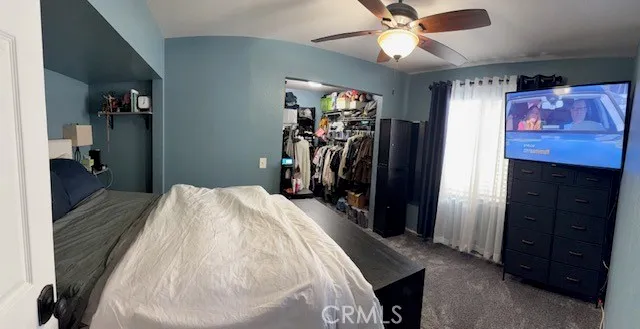 a bed room with a bed and a ceiling fan