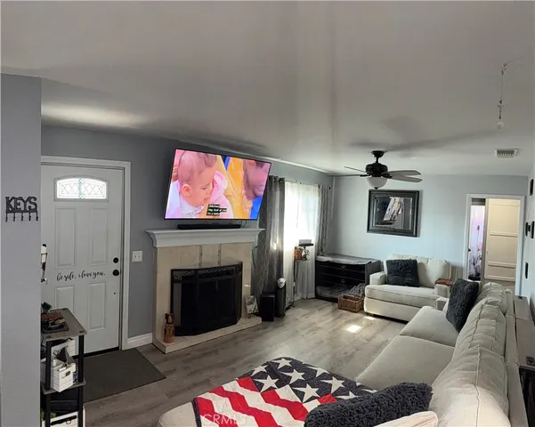 a living room with furniture a flat screen tv and a fireplace