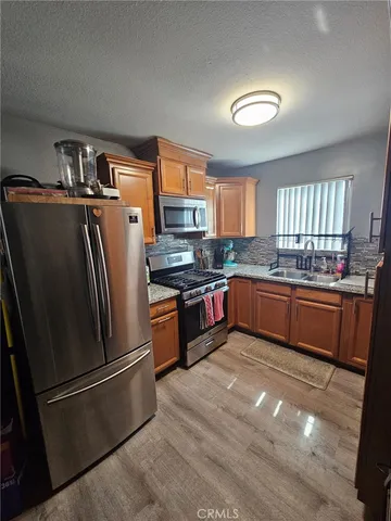 a kitchen with stainless steel appliances granite countertop a refrigerator a sink a stove a microwave a counter space and cabinets