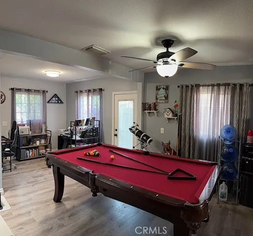 a room with furniture pool table flat screen tv and windows