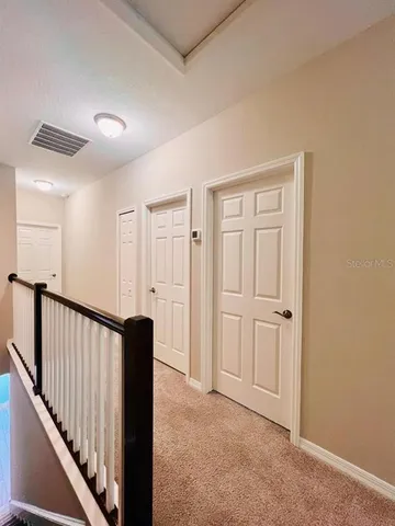 a view of a hallway with wooden floor and staircase