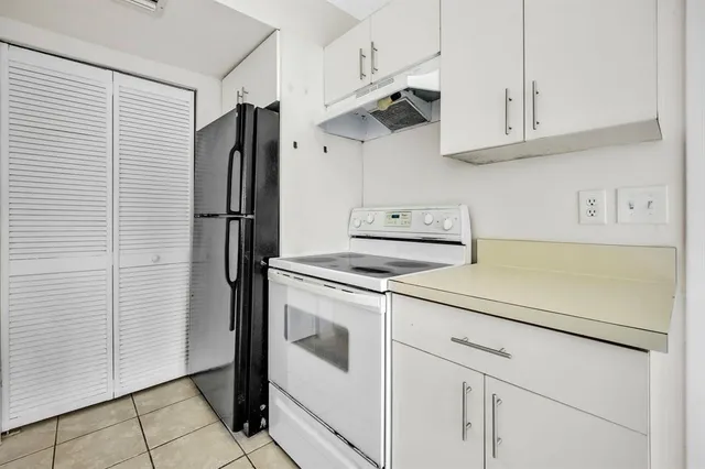 a kitchen with stainless steel appliances white cabinets and a refrigerator