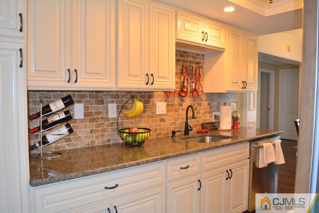39 B Haddon Road Monroe Township, NJ 08831 - Photo 4 of 22 a kitchen with stainless steel appliances granite countertop a sink a stove and white cabinets