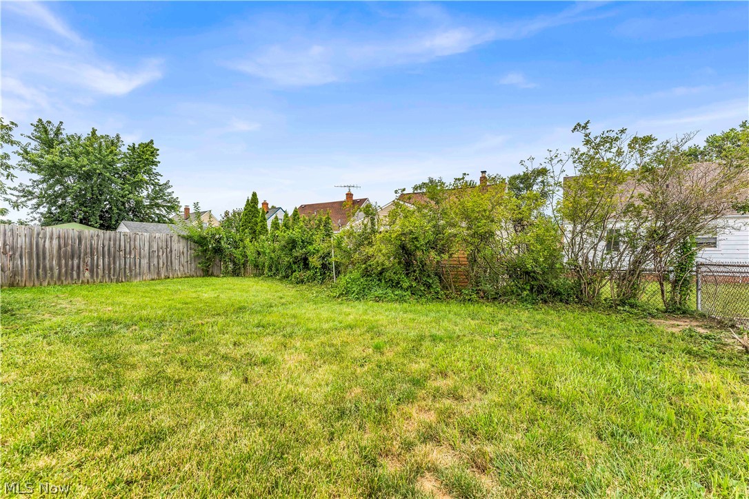 30015 Warren Road Wickliffe, OH 44092 - Photo 19 of 23 Expansive green lawn with mature perimeter trees and a wood fence